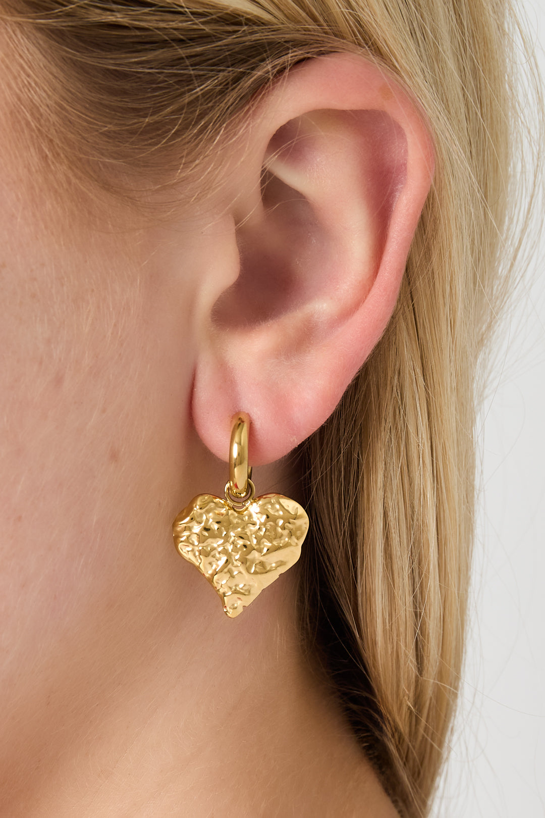 Goud RVS Hart Oorbellen Goud – Textured Heart Hoop Statement – gedragen op model | Tudor Gems